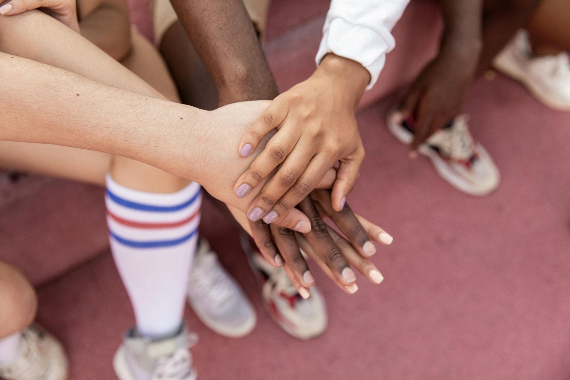 Faceless multiracial sport team stacking hands on court